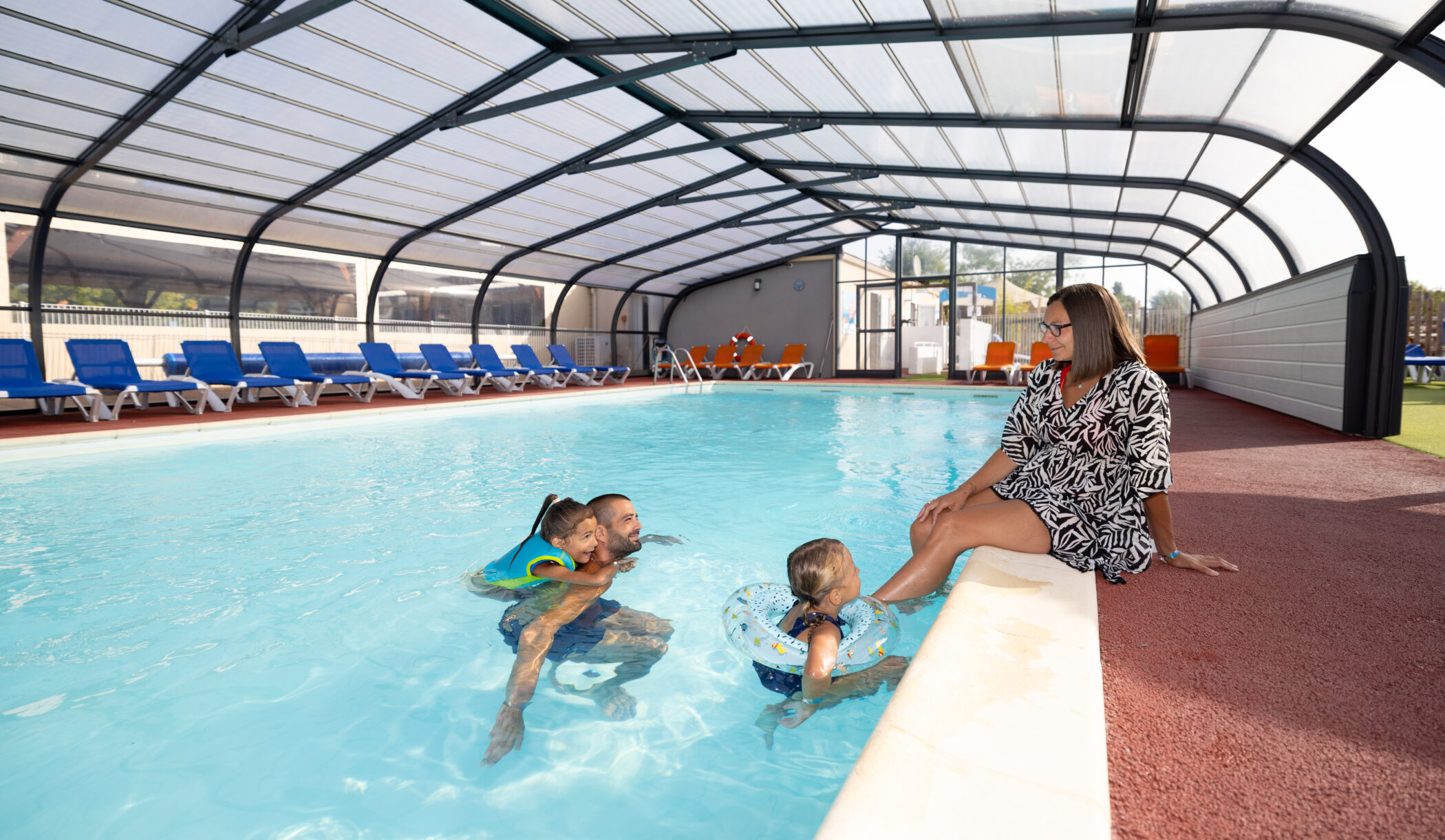 Famille dans la piscine couverte chauffée du camping, à 20 minutes du Puy du Fou en Vendée