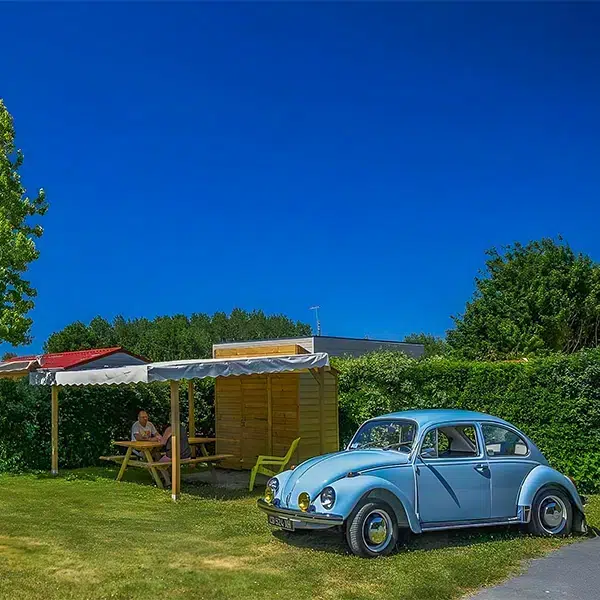 Emplacement Privilège Garden avec abri couvert et table en bois, camping proche du Puy du Fou